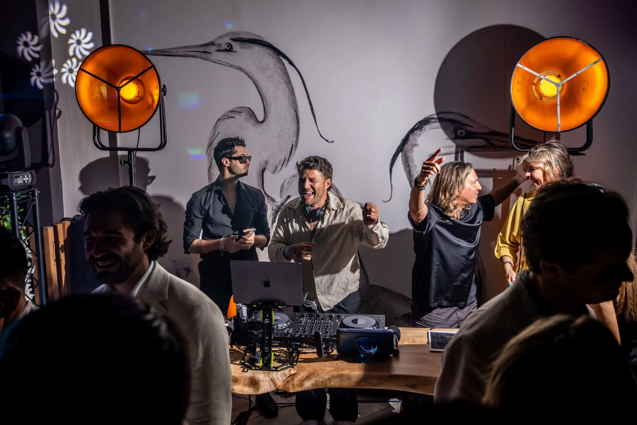 Guests gathered at the DJ booth under warm stage lights during an evening event