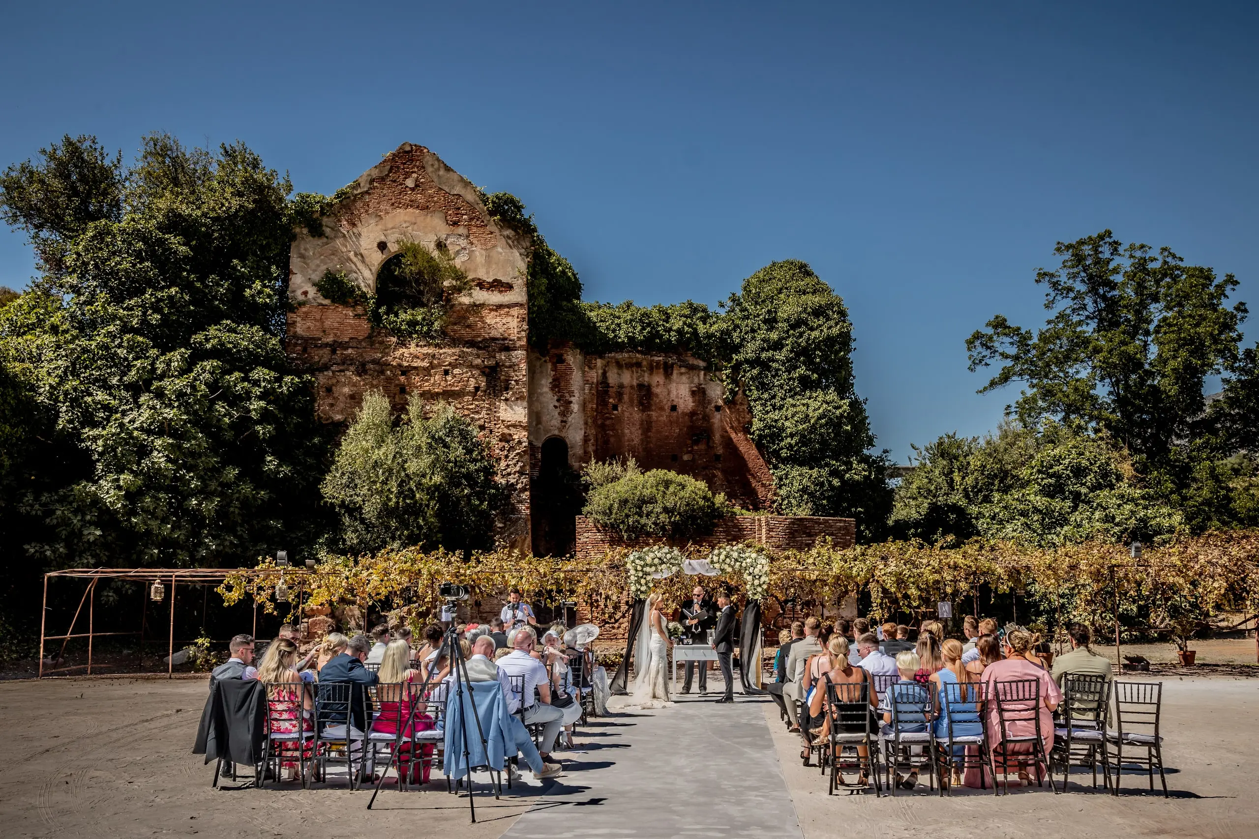 A ceremony set up in a terraced garden with florals and staging before guests arrive